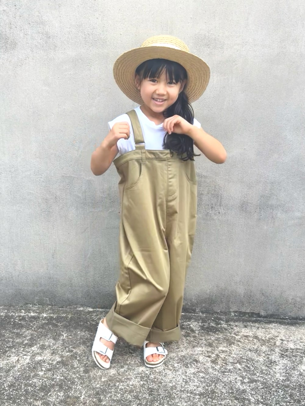 ベージュ系のサロペット/オーバーオール、ホワイト系のサンダル、ベージュ系のハットを着用したキッズの夏コーディネートの2枚目の写真