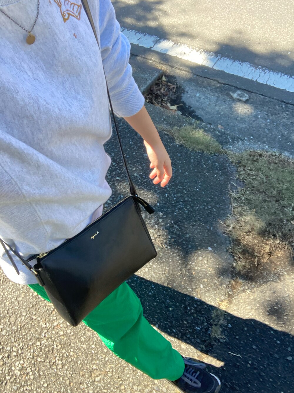 グレー系のスウェット、ブラック系のショルダーバッグ、グリーン系のその他パンツを着用したレディースの秋コーディネートの2枚目の写真