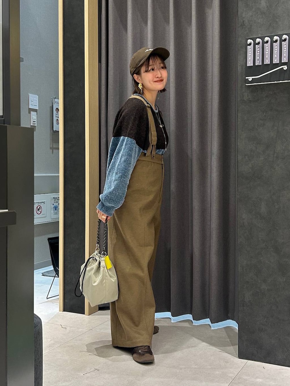 ブラウン系のスニーカー、グレー系のショルダーバッグ、ベージュ系のその他パンツを着用したレディースの秋コーディネートの3枚目の写真