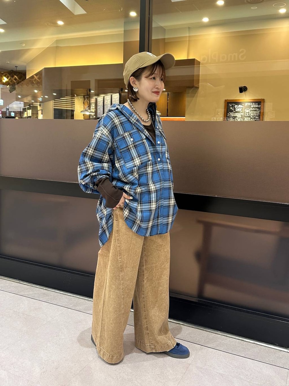 ブラウン系のデニムパンツ、ブルー系のシャツ/ブラウス、ブラウン系のTシャツ/カットソーを着用したレディースの夏コーディネートの3枚目の写真