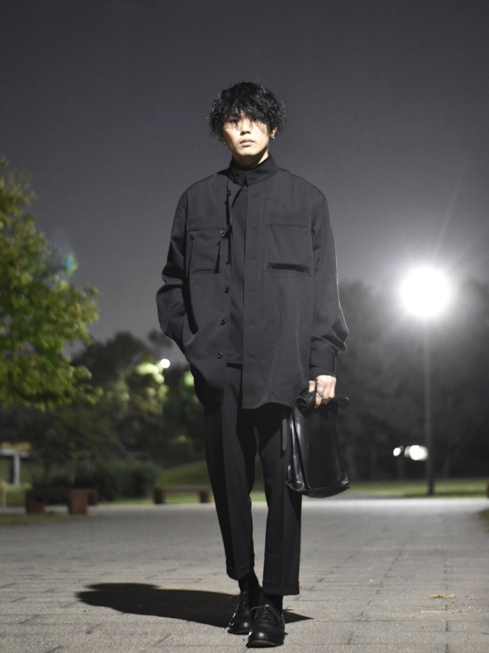 ブラック系のシャツ/ブラウス、ブラック系のクラッチバッグ、ブラック系のスラックスを着用したメンズの秋コーディネートの3枚目の写真