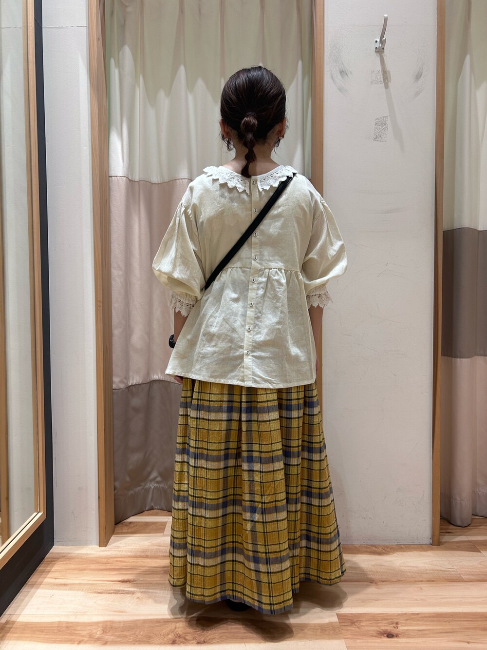 イエロー系のスカート、ホワイト系のシャツ/ブラウス、ブラック系のハンドバッグを着用したレディースの春コーディネートの4枚目の写真