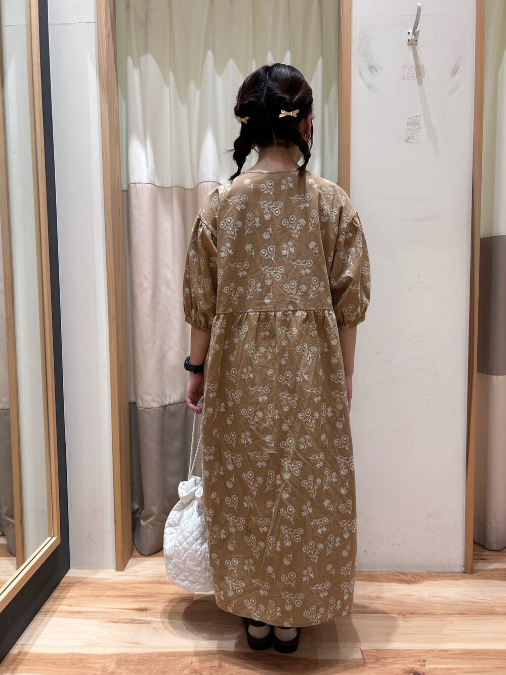 ベージュ系のワンピース、ホワイト系のスカート、ホワイト系のハンドバッグを着用したレディースの春コーディネートの3枚目の写真