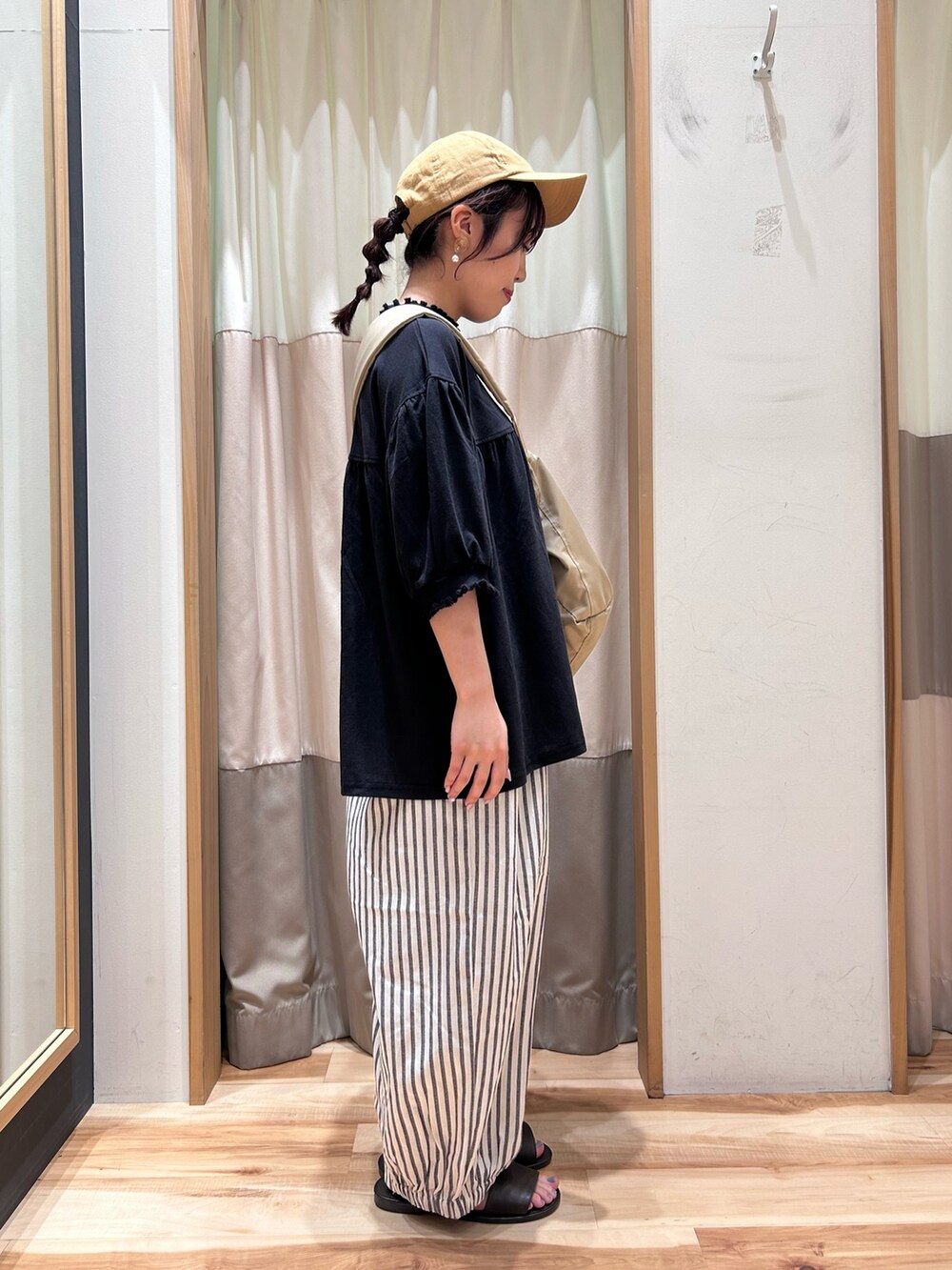 ブラック系のTシャツ/カットソー、グレー系のその他パンツ、ベージュ系のハンドバッグを着用したレディースの夏コーディネートの2枚目の写真