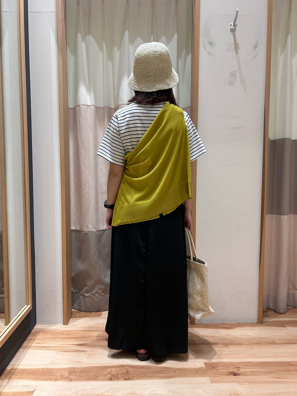 ホワイト系のハンドバッグ、ホワイト系のワンピース、イエロー系のカーディガン/ボレロを着用したレディースの夏コーディネートの4枚目の写真