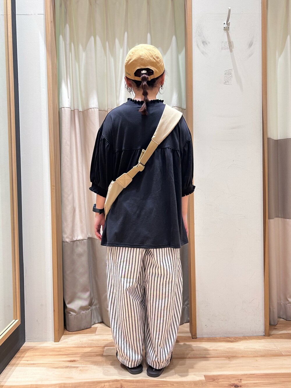 ブラック系のTシャツ/カットソー、グレー系のその他パンツ、ベージュ系のハンドバッグを着用したレディースの夏コーディネートの3枚目の写真
