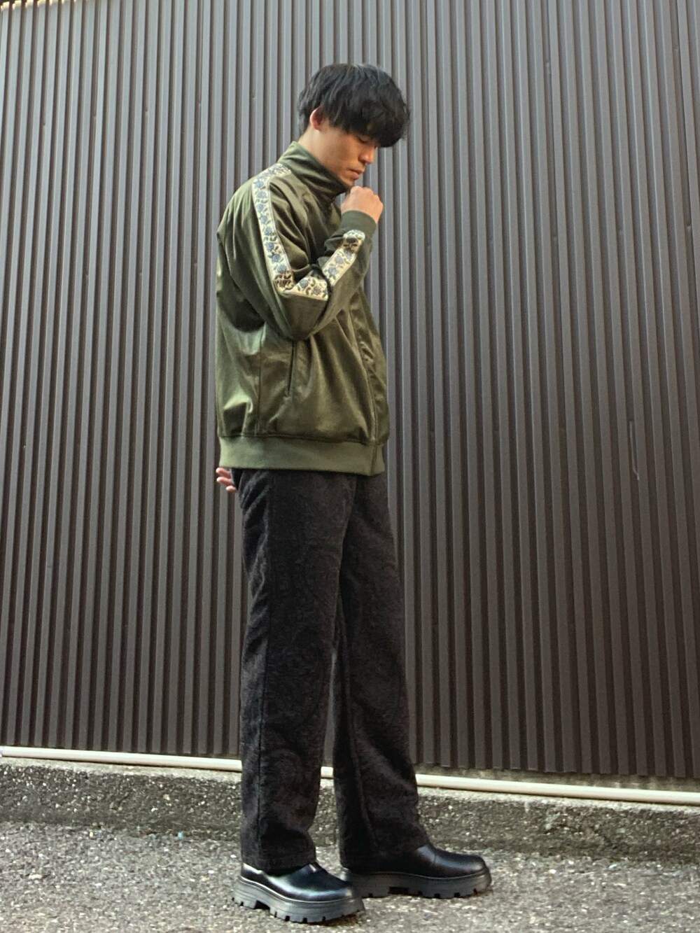 グリーン系のブルゾン、ホワイト系のTシャツ/カットソー、ブラック系のその他パンツを着用したメンズの秋コーディネートの2枚目の写真