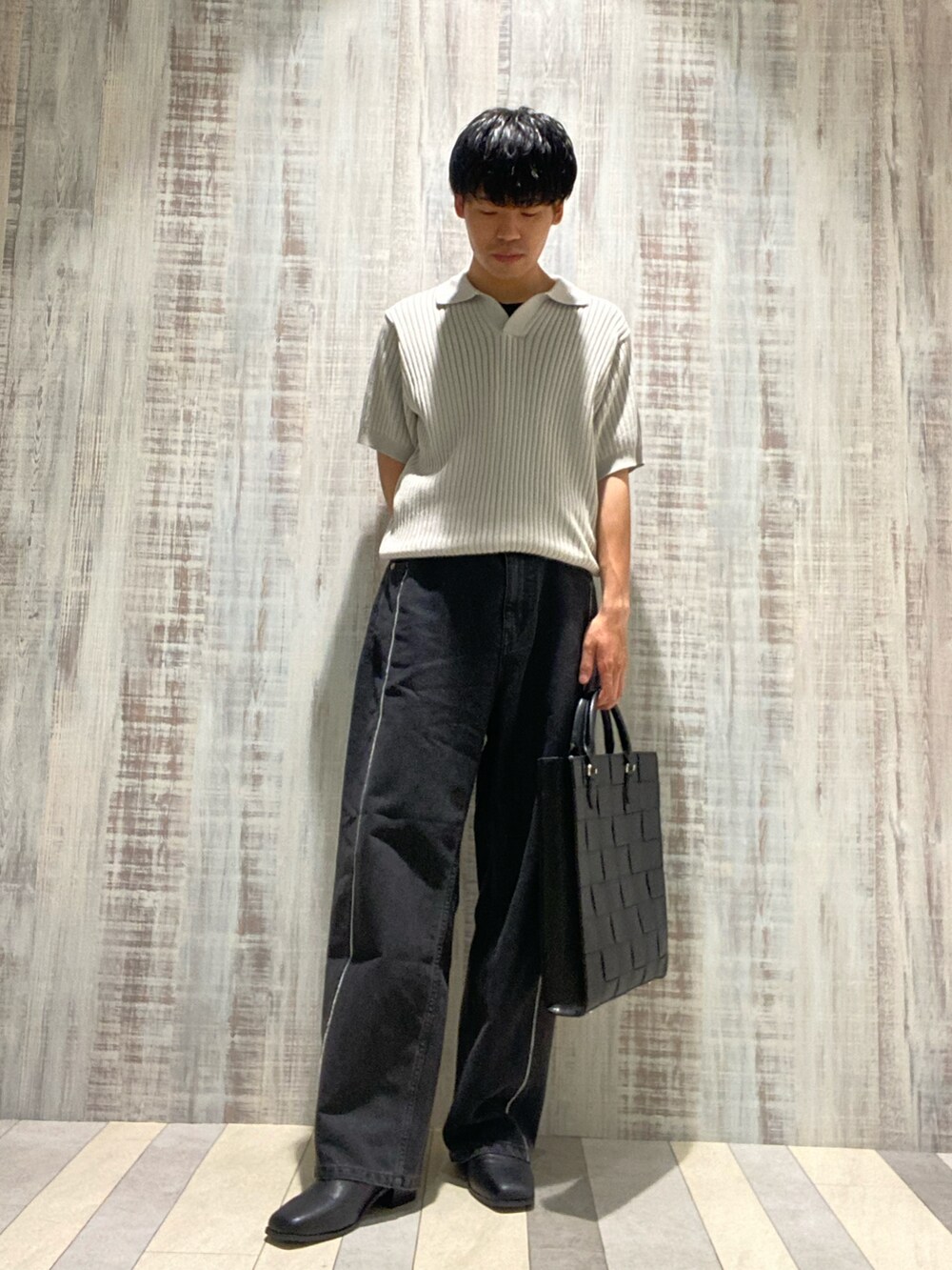 グレー系のポロシャツ、グレー系のデニムパンツ、ブラック系のサンダルを着用したメンズの夏コーディネートの2枚目の写真