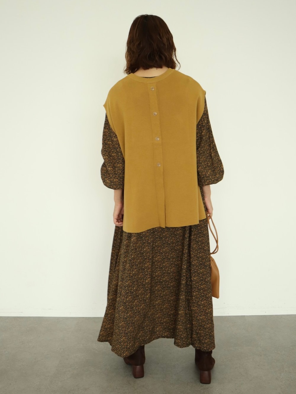 その他のワンピース、イエロー系のベスト、ゴールド系のピアス（片耳用）を着用したレディースの秋コーディネートの3枚目の写真