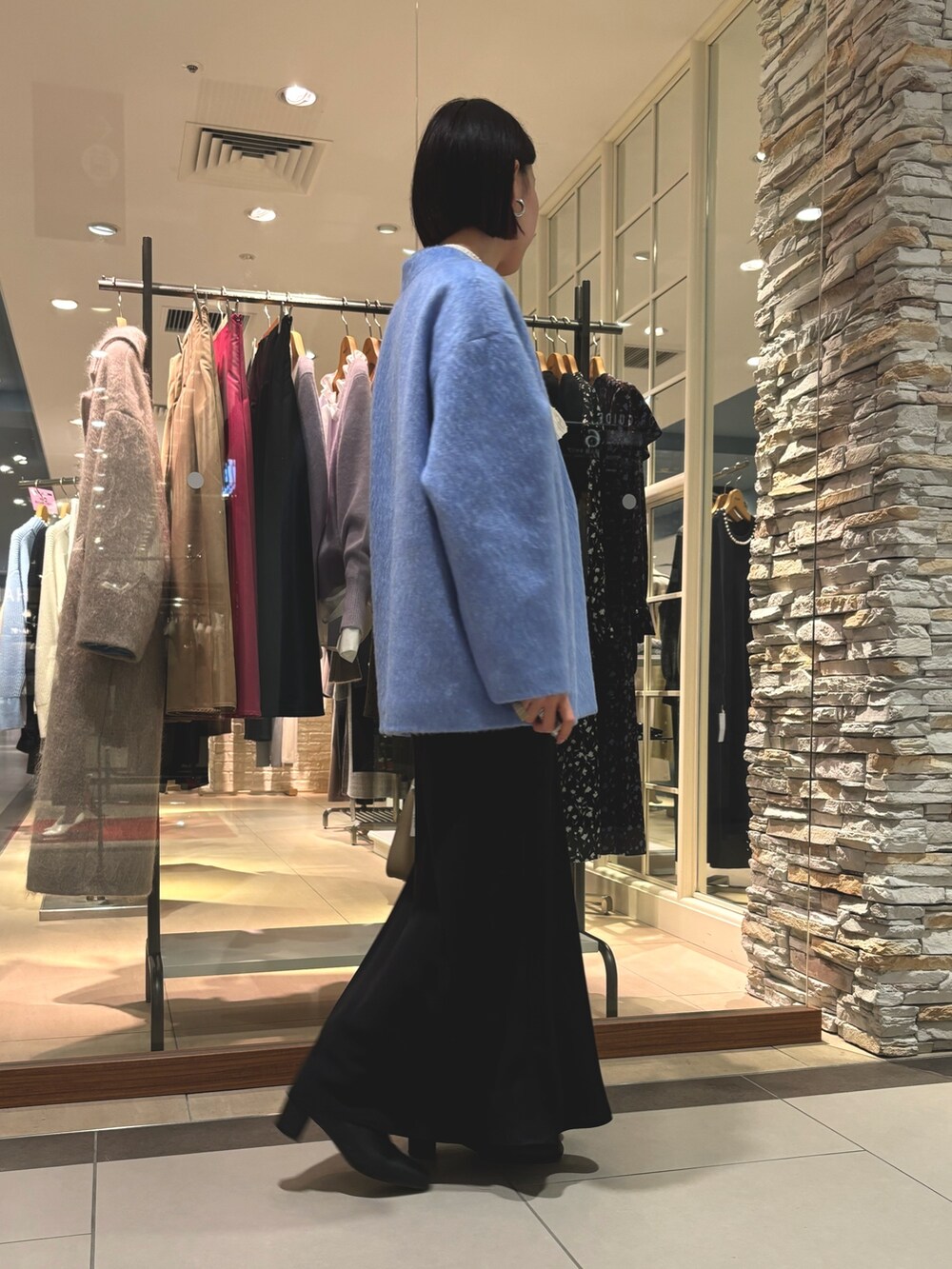 ブラック系のスカート、ベージュ系のショルダーバッグ、ブルー系のその他アウターを着用したレディースの冬コーディネートの5枚目の写真