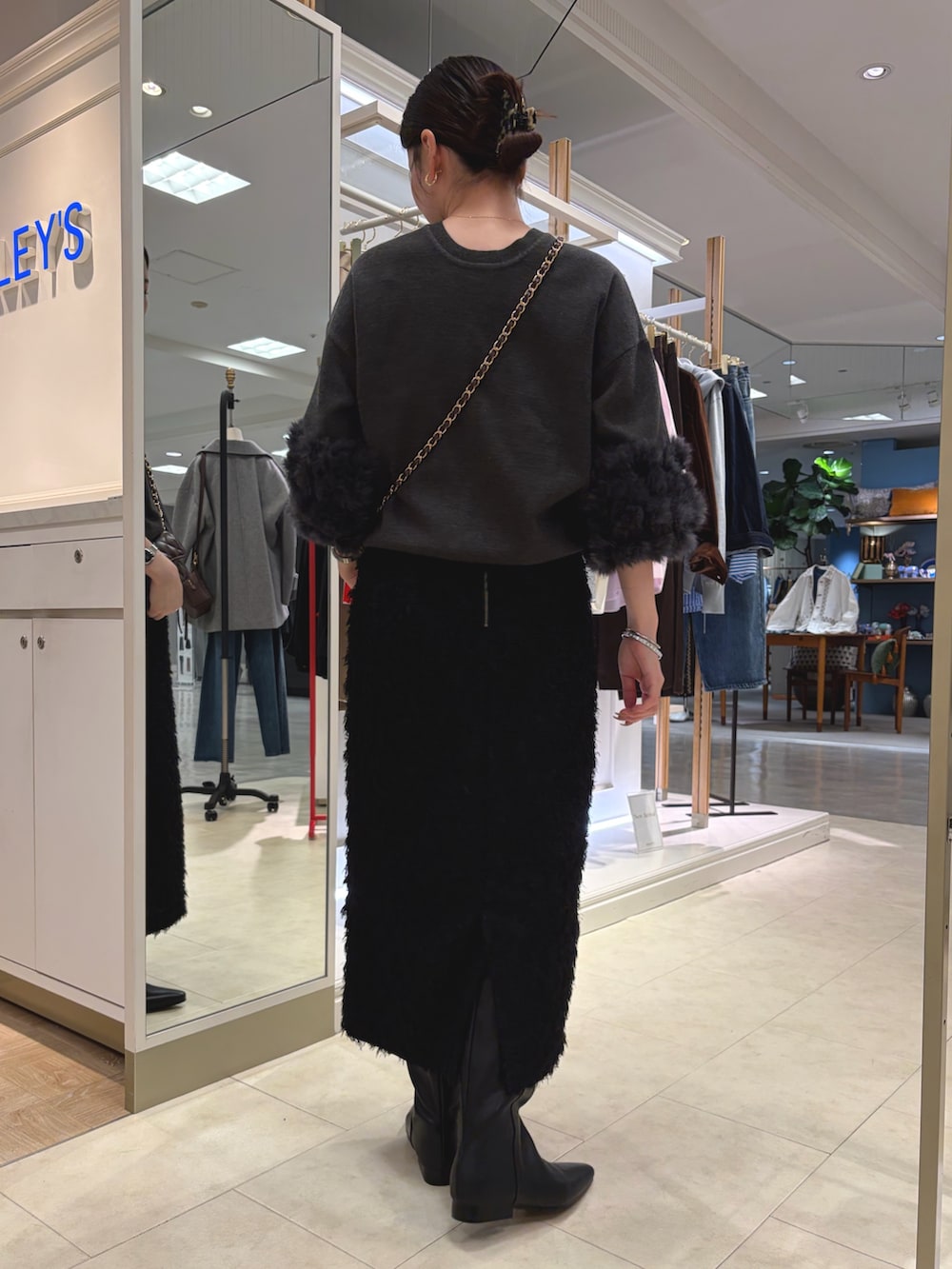 ブラック系のスカート、ブラック系のショルダーバッグ、グレー系のカーディガン/ボレロを着用したレディースの秋コーディネートの4枚目の写真