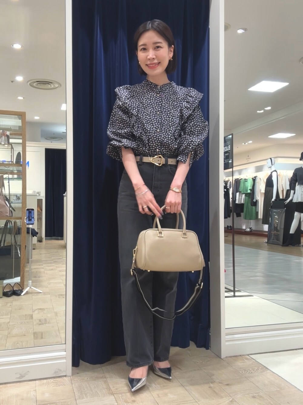 ベージュ系のショルダーバッグ、グレー系のデニムパンツ、ブラック系のシャツ/ブラウスを着用したレディースの秋コーディネートの5枚目の写真