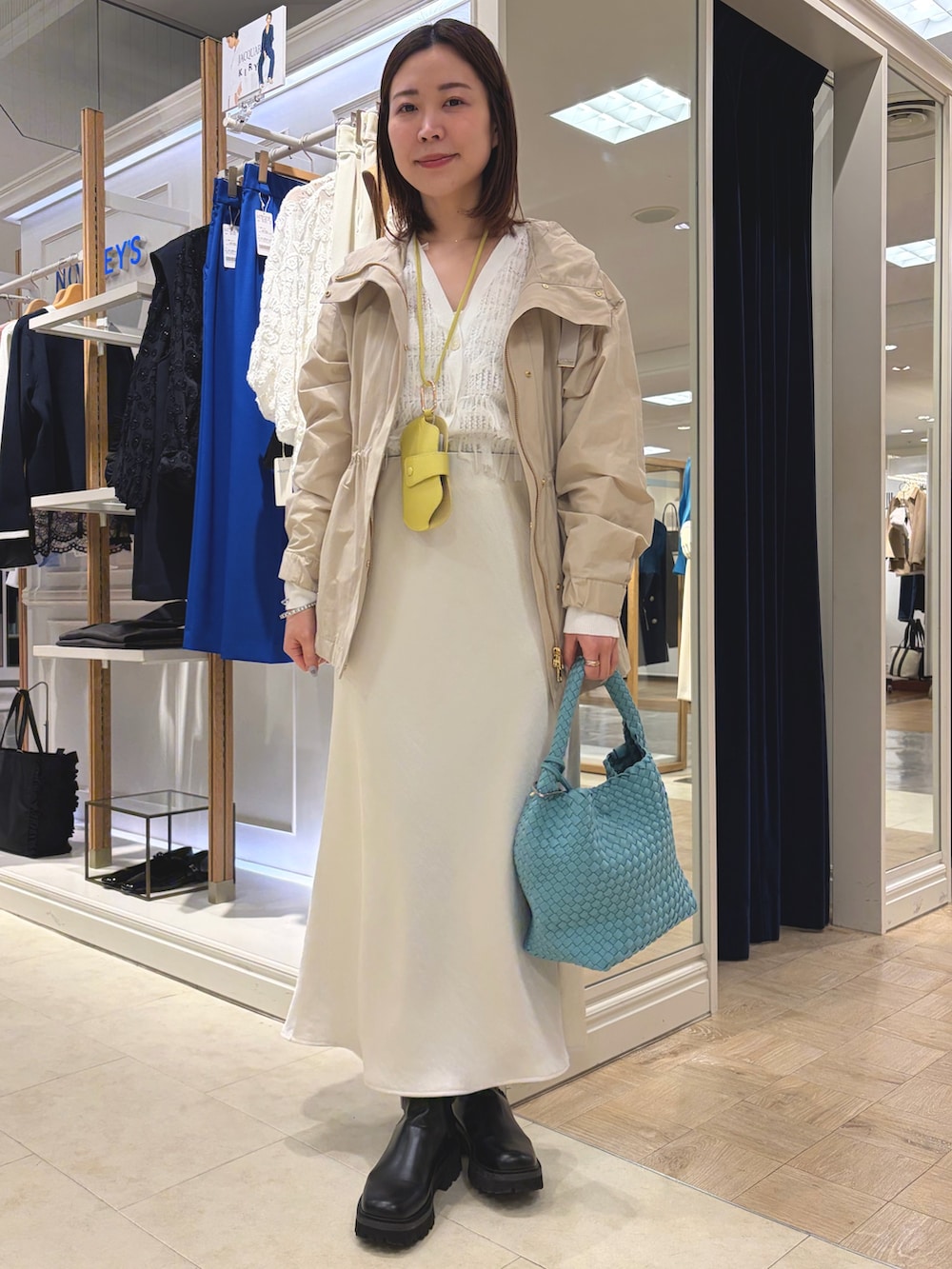 ベージュ系のブルゾン、ホワイト系のスカート、ブルー系のショルダーバッグを着用したレディースの春コーディネートの5枚目の写真