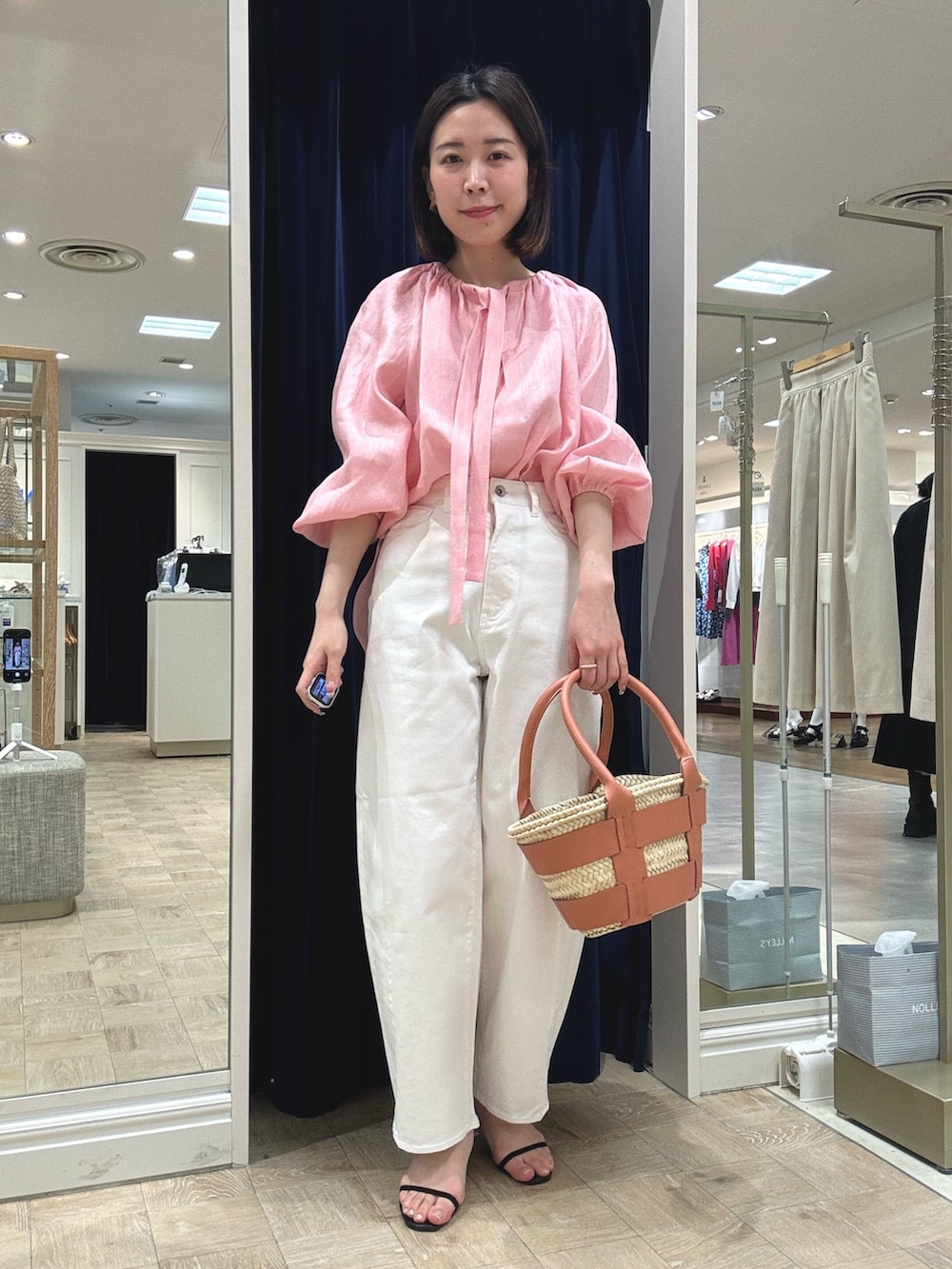 ピンク系のシャツ/ブラウス、ホワイト系のデニムパンツを着用したレディースの春コーディネートの2枚目の写真