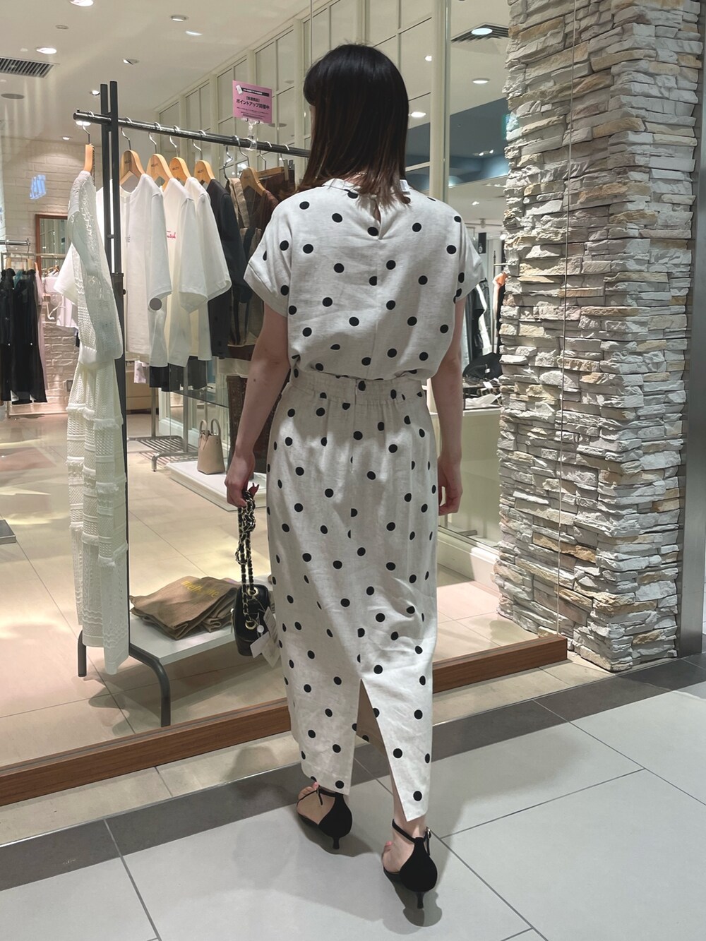 ブラック系のサンダル、ベージュ系のスカート、ブラック系のシャツ/ブラウスを着用したレディースの夏コーディネートの3枚目の写真