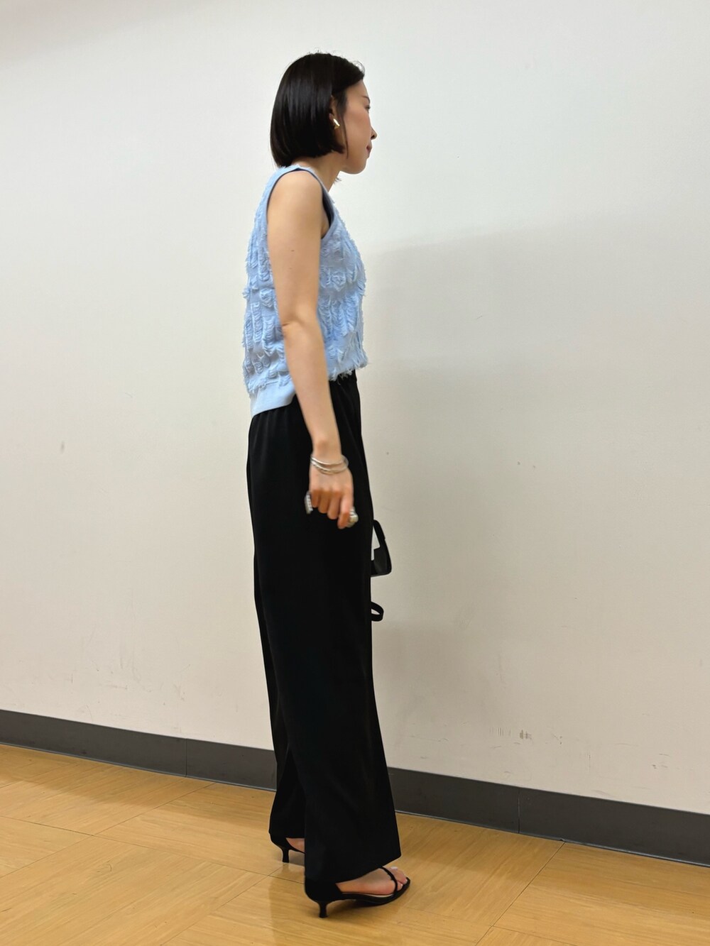 ブラック系のその他パンツ、ブラック系のハンドバッグ、ブルー系のニット/セーターを着用したレディースの春コーディネートの4枚目の写真