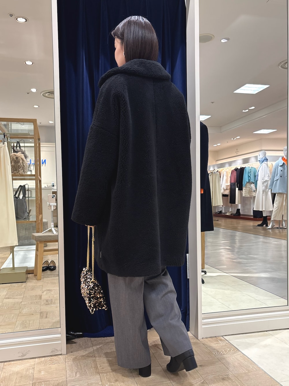 ピンク系のニット/セーター、ブラック系のダッフルコート、その他のショルダーバッグを着用したレディースの冬コーディネートの4枚目の写真