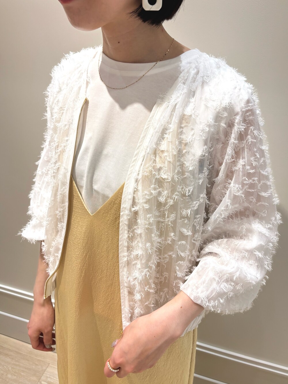 イエロー系のワンピース、ホワイト系のブルゾン、ホワイト系のTシャツ/カットソーを着用したレディースの夏コーディネートの7枚目の写真