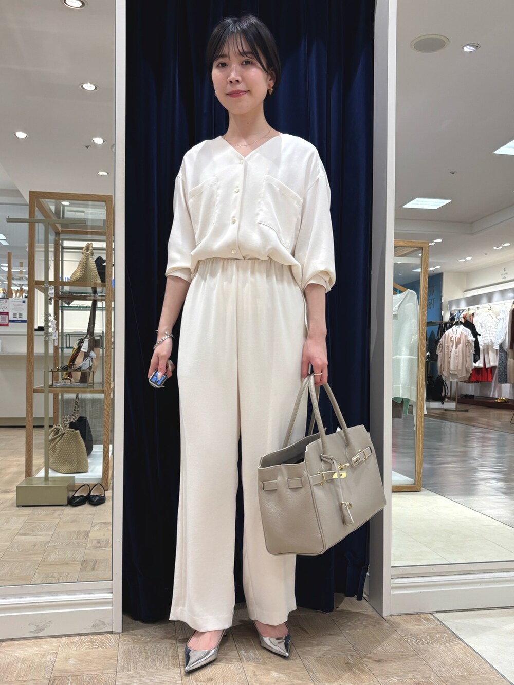 ホワイト系のシャツ/ブラウス、ホワイト系のその他パンツ、ベージュ系のトートバッグを着用したレディースの春コーディネートの2枚目の写真