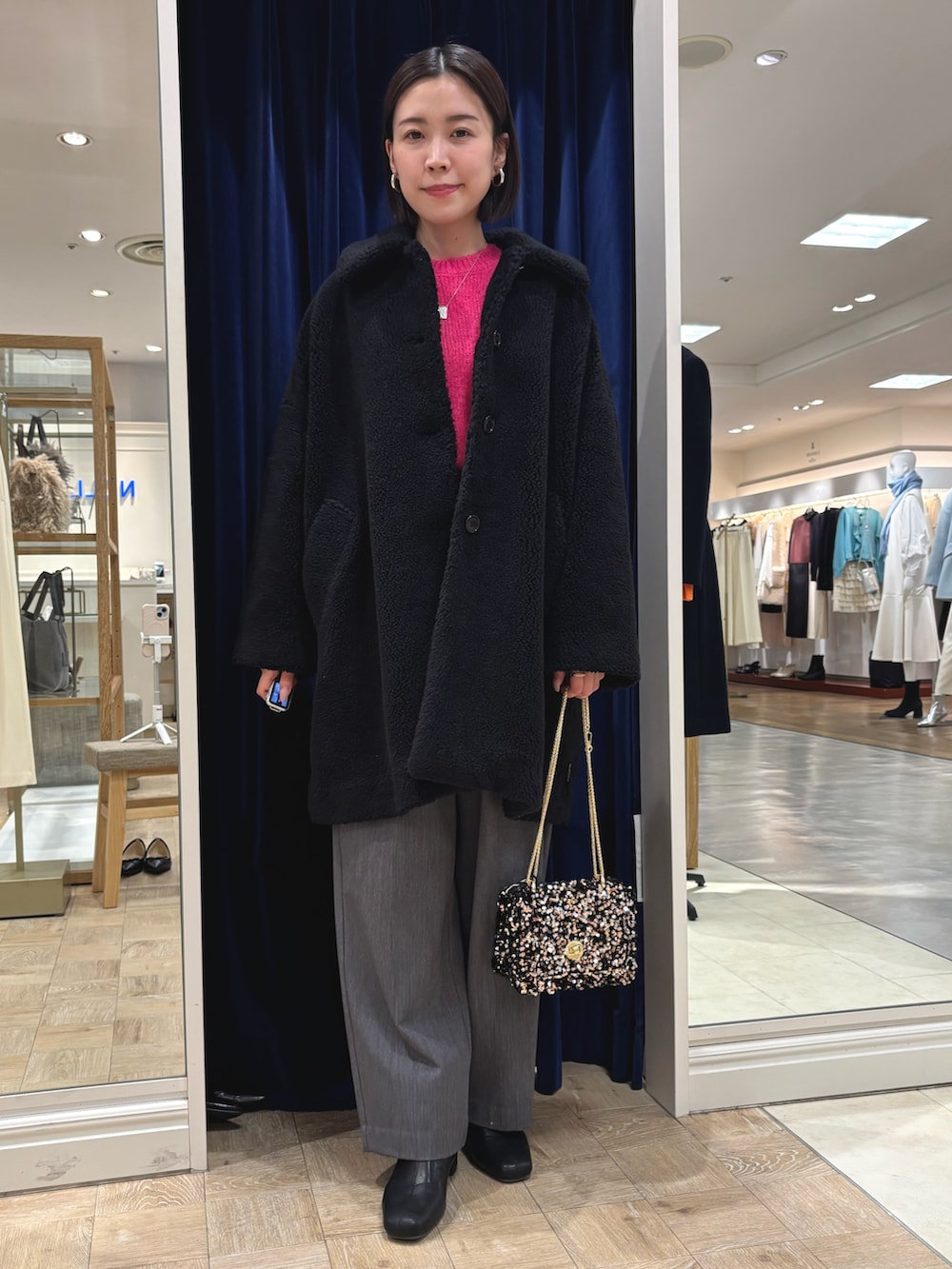 ピンク系のニット/セーター、ブラック系のダッフルコート、その他のショルダーバッグを着用したレディースの冬コーディネートの2枚目の写真