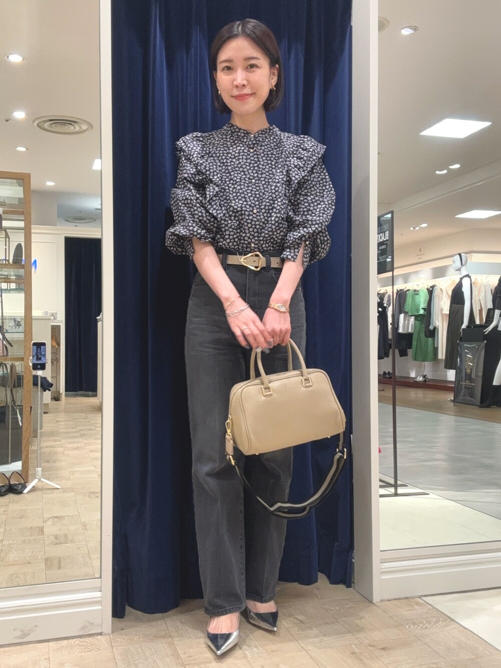 ベージュ系のショルダーバッグ、グレー系のデニムパンツ、ブラック系のシャツ/ブラウスを着用したレディースの秋コーディネートの2枚目の写真