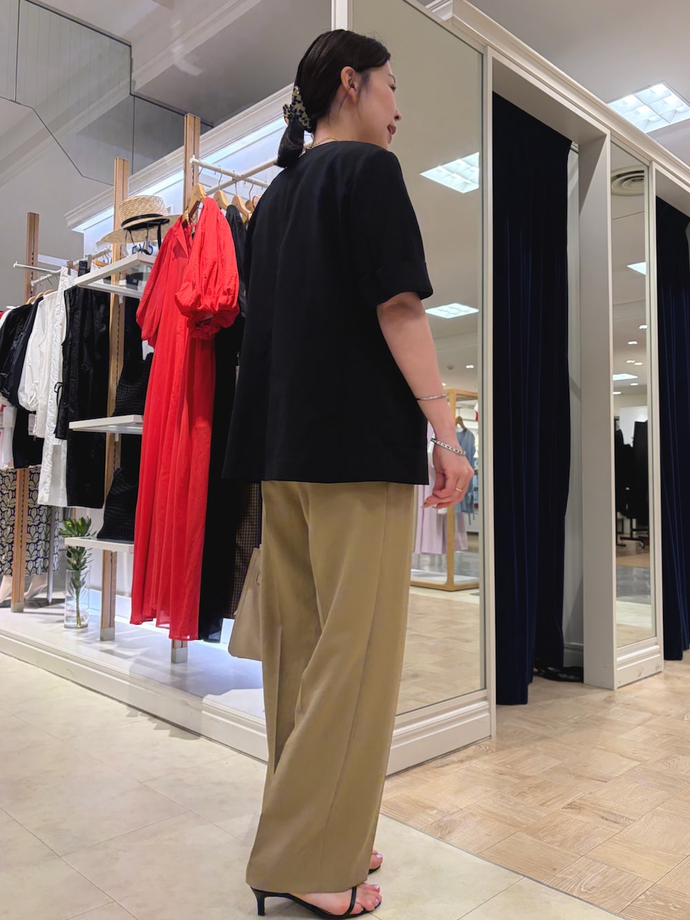 ベージュ系のトートバッグ、ブラック系のノーカラージャケット、ホワイト系のTシャツ/カットソーを着用したレディースの夏コーディネートの3枚目の写真