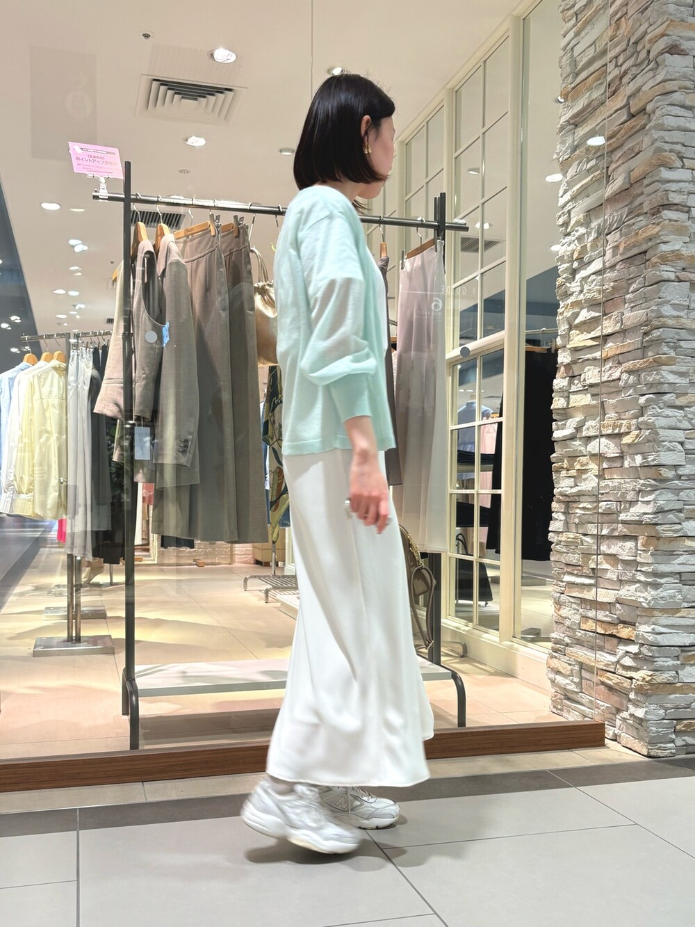 ホワイト系のスカート、ブラック系のショルダーバッグ、ホワイト系のTシャツ/カットソーを着用したレディースの春コーディネートの3枚目の写真