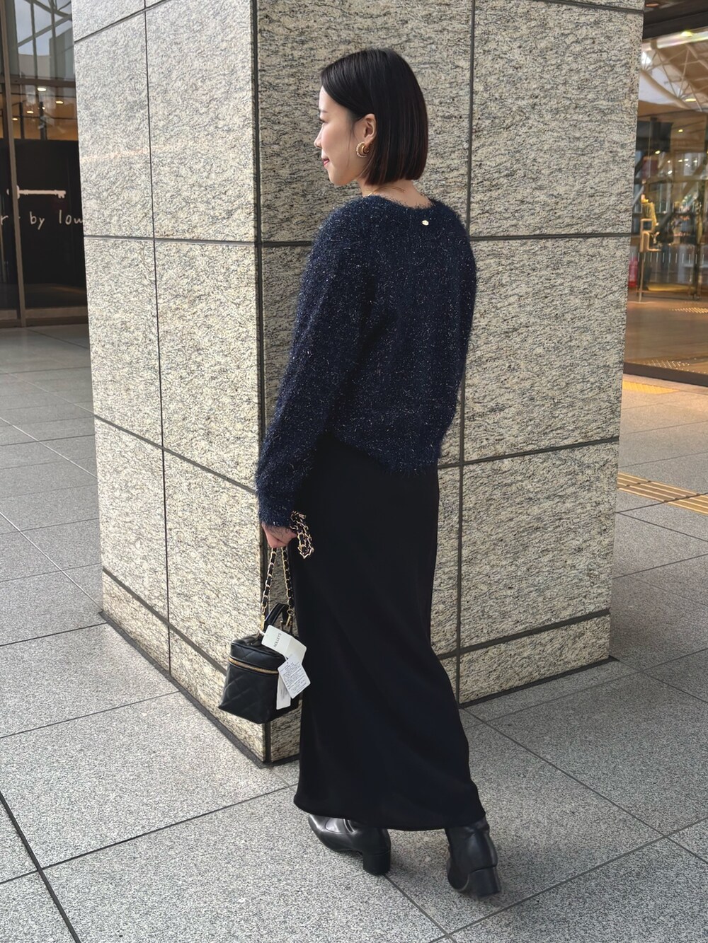 ブラック系のスカート、ブラック系のショルダーバッグ、ブルー系のカーディガン/ボレロを着用したレディースの冬コーディネートの5枚目の写真