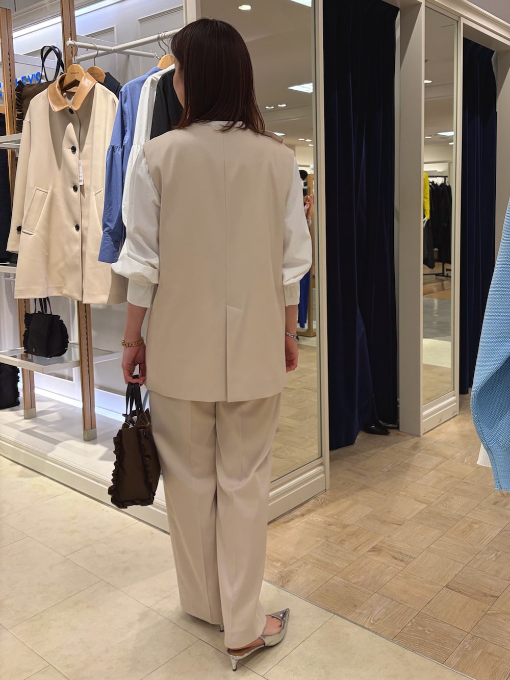 ホワイト系のベスト、ホワイト系のその他パンツ、ブラウン系のショルダーバッグを着用したレディースの冬コーディネートの4枚目の写真