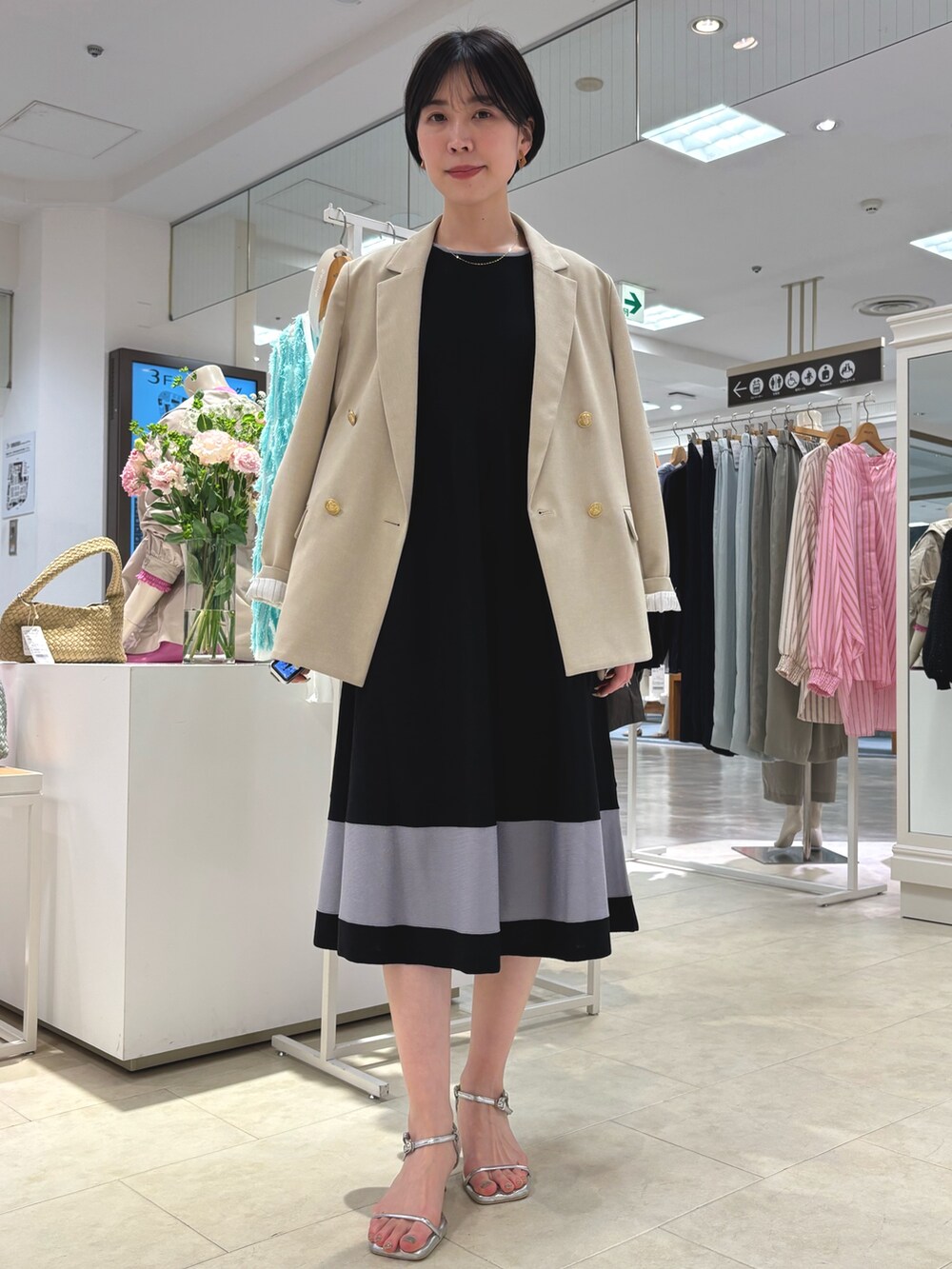 ベージュ系のテーラードジャケット、ブラック系のワンピース、ゴールド系のネックレスを着用したレディースの春コーディネートの2枚目の写真