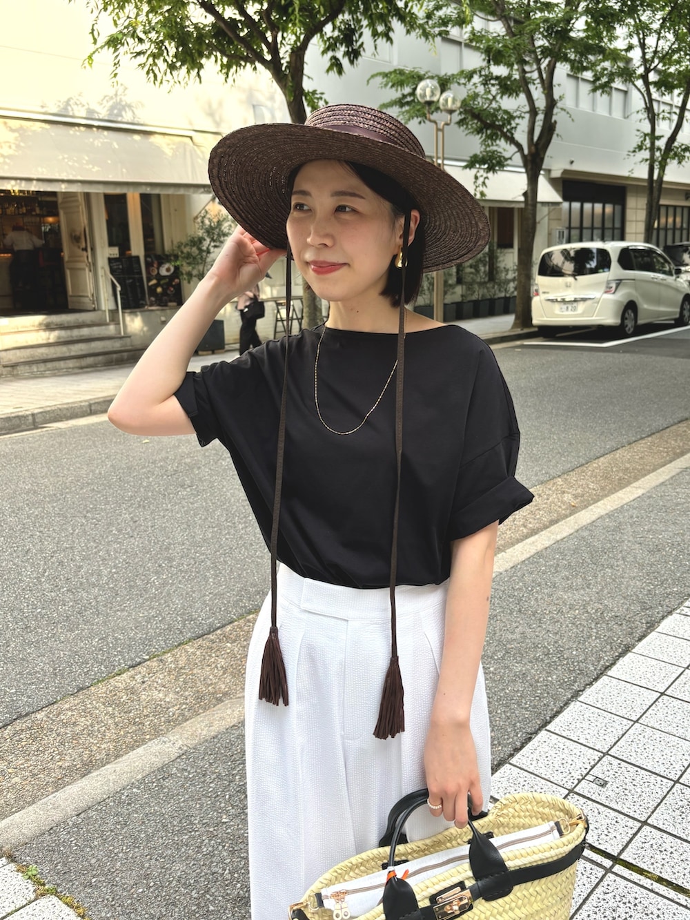 ホワイト系のその他パンツ、ブラック系のTシャツ/カットソー、ブラック系のかごバッグを着用したレディースの夏コーディネートの6枚目の写真