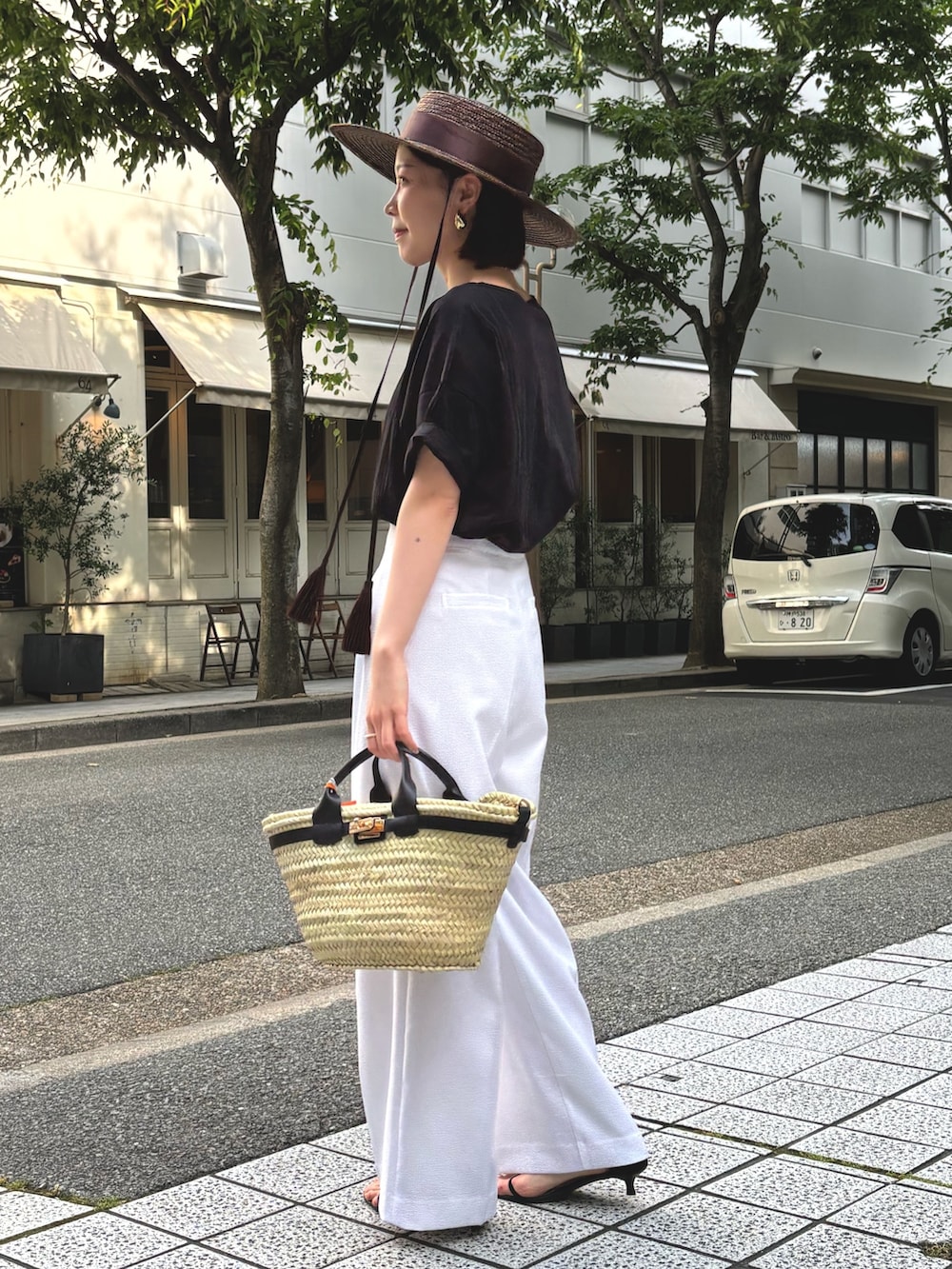 ホワイト系のその他パンツ、ブラック系のTシャツ/カットソー、ブラック系のかごバッグを着用したレディースの夏コーディネートの4枚目の写真