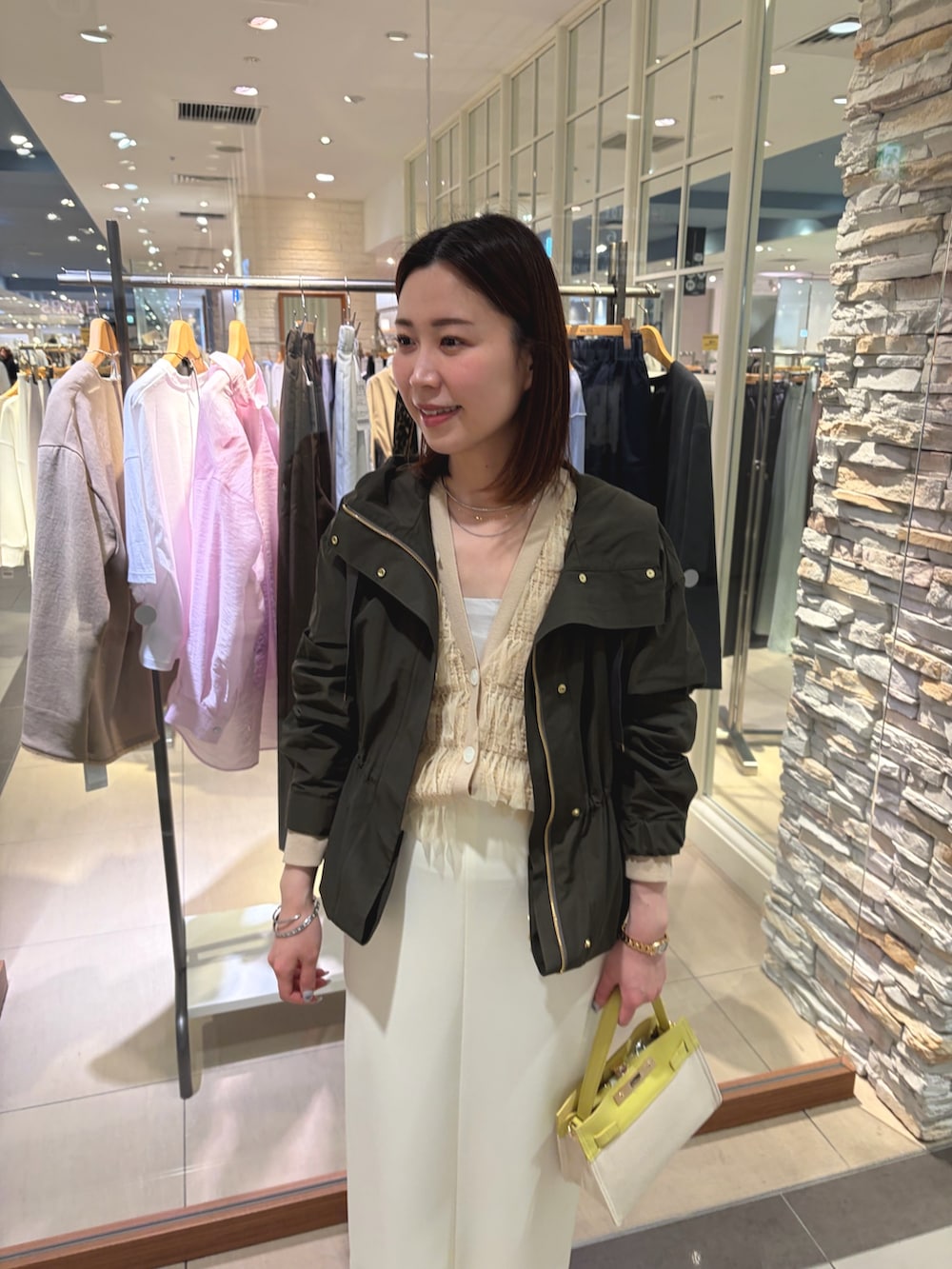 ホワイト系のスカート、イエロー系のショルダーバッグ、ベージュ系のカーディガン/ボレロを着用したレディースの春コーディネートの5枚目の写真