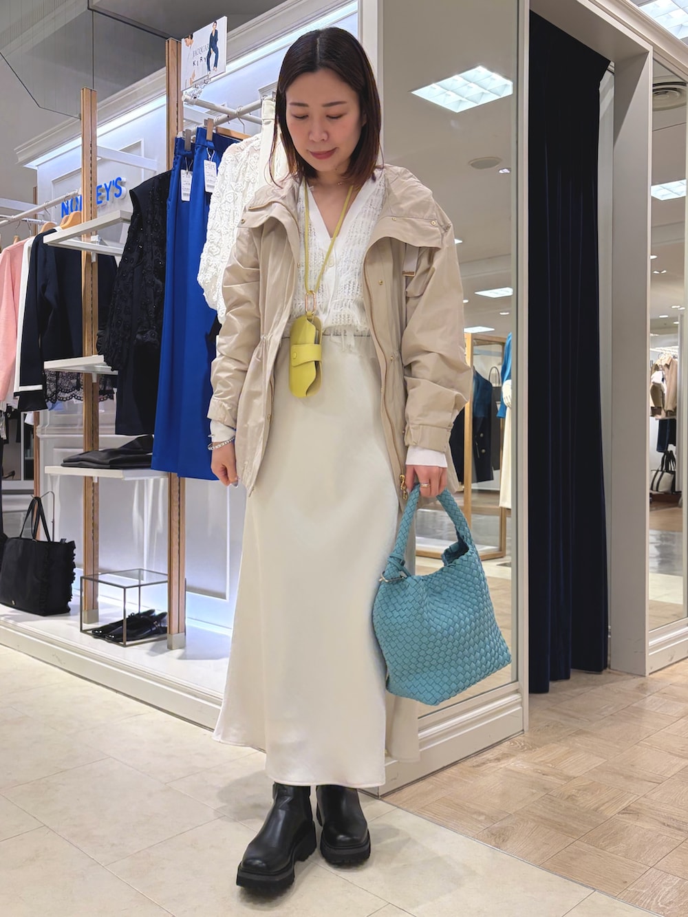 ベージュ系のブルゾン、ホワイト系のスカート、ブルー系のショルダーバッグを着用したレディースの春コーディネートの2枚目の写真