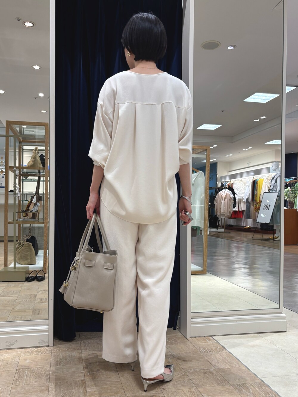ホワイト系のシャツ/ブラウス、ホワイト系のその他パンツ、ベージュ系のトートバッグを着用したレディースの春コーディネートの5枚目の写真