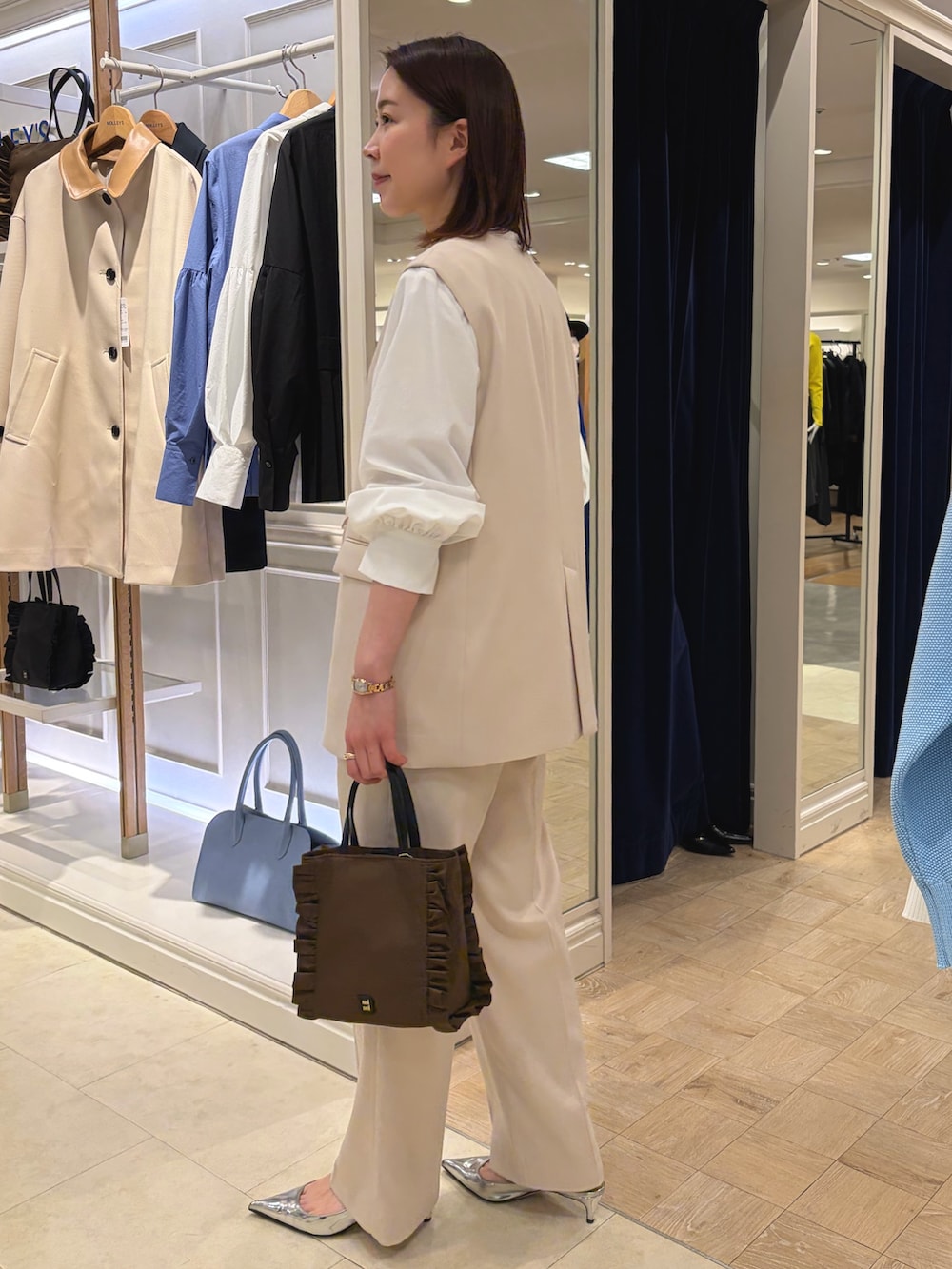 ホワイト系のベスト、ホワイト系のその他パンツ、ブラウン系のショルダーバッグを着用したレディースの冬コーディネートの3枚目の写真