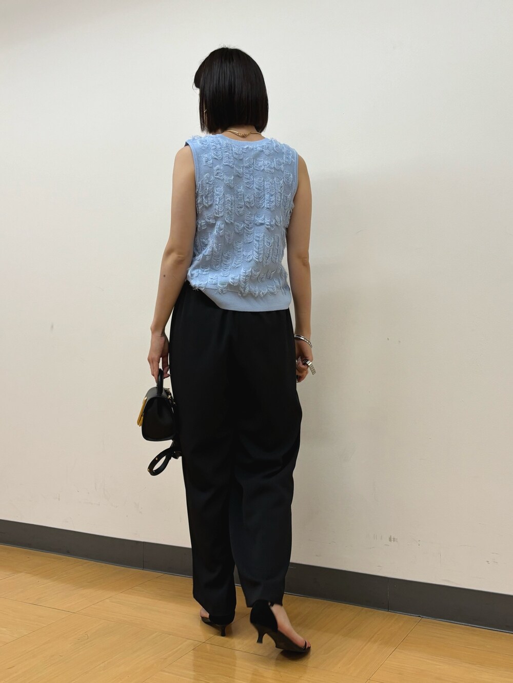 ブラック系のその他パンツ、ブラック系のハンドバッグ、ブルー系のニット/セーターを着用したレディースの春コーディネートの5枚目の写真