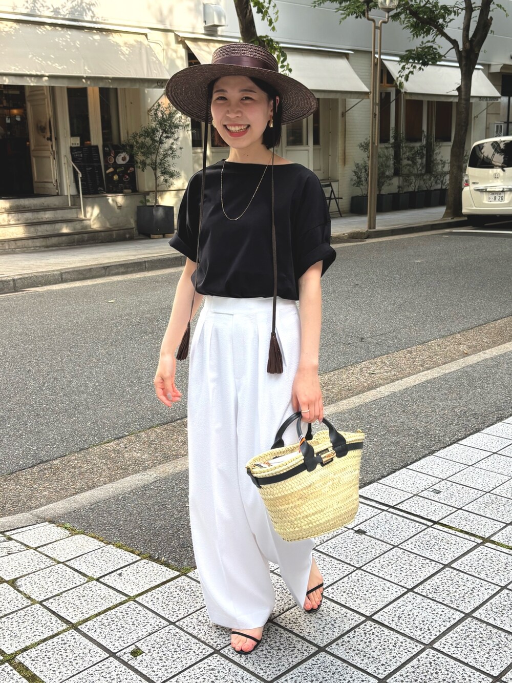 ホワイト系のその他パンツ、ブラック系のTシャツ/カットソー、ブラック系のかごバッグを着用したレディースの夏コーディネートの3枚目の写真