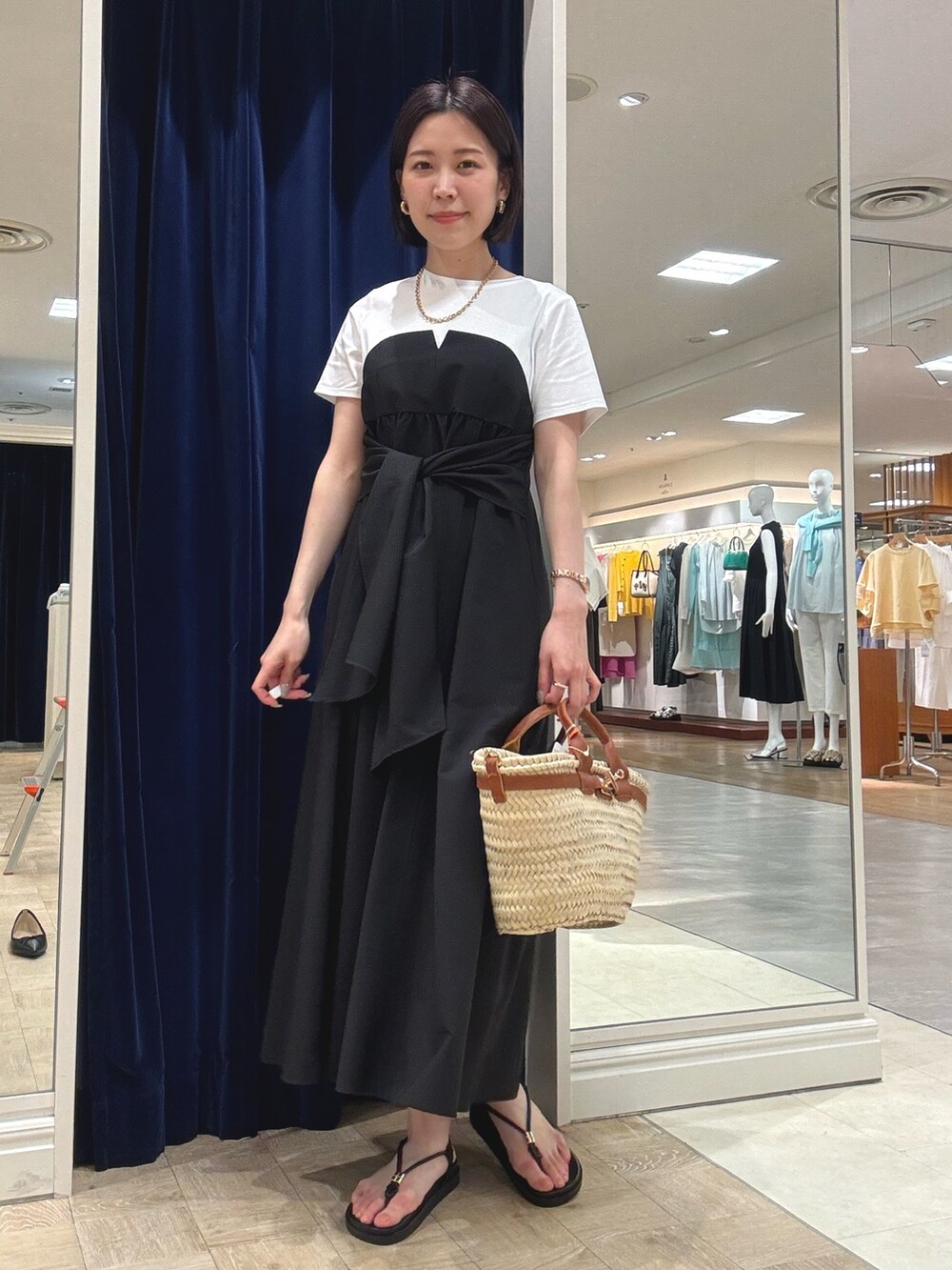 ブラック系のワンピース、ブラウン系のかごバッグ、ブラック系のサンダルを着用したレディースの夏コーディネートの3枚目の写真