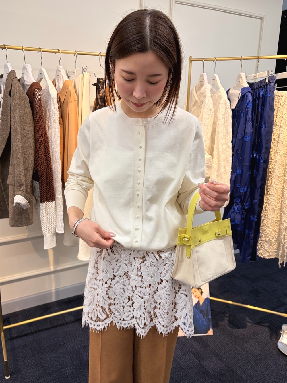 ホワイト系のカーディガン/ボレロ、ホワイト系のキャミソール、イエロー系のその他パンツを着用したレディースの冬コーディネートの5枚目の写真