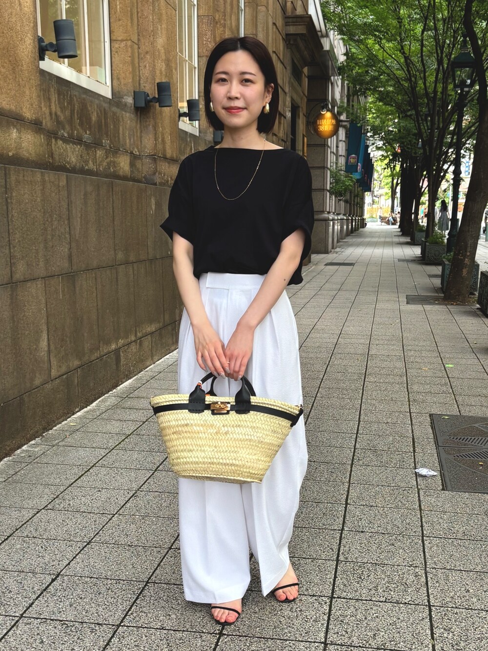 ホワイト系のその他パンツ、ブラック系のTシャツ/カットソー、ブラック系のかごバッグを着用したレディースの夏コーディネートの8枚目の写真