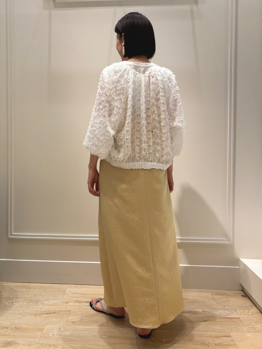 イエロー系のワンピース、ホワイト系のブルゾン、ホワイト系のTシャツ/カットソーを着用したレディースの夏コーディネートの5枚目の写真