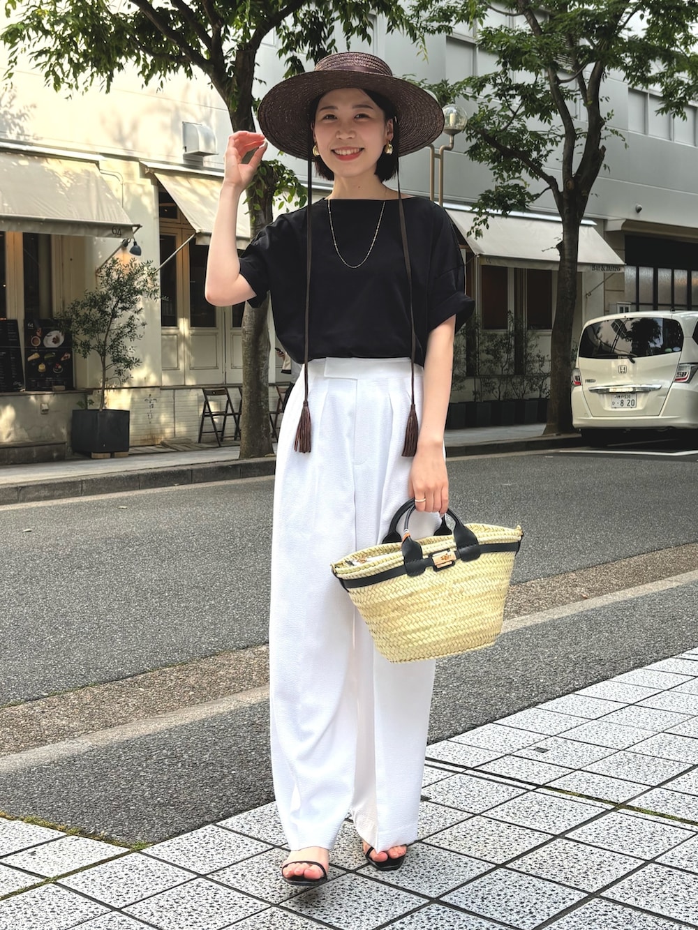 ホワイト系のその他パンツ、ブラック系のTシャツ/カットソー、ブラック系のかごバッグを着用したレディースの夏コーディネートの2枚目の写真