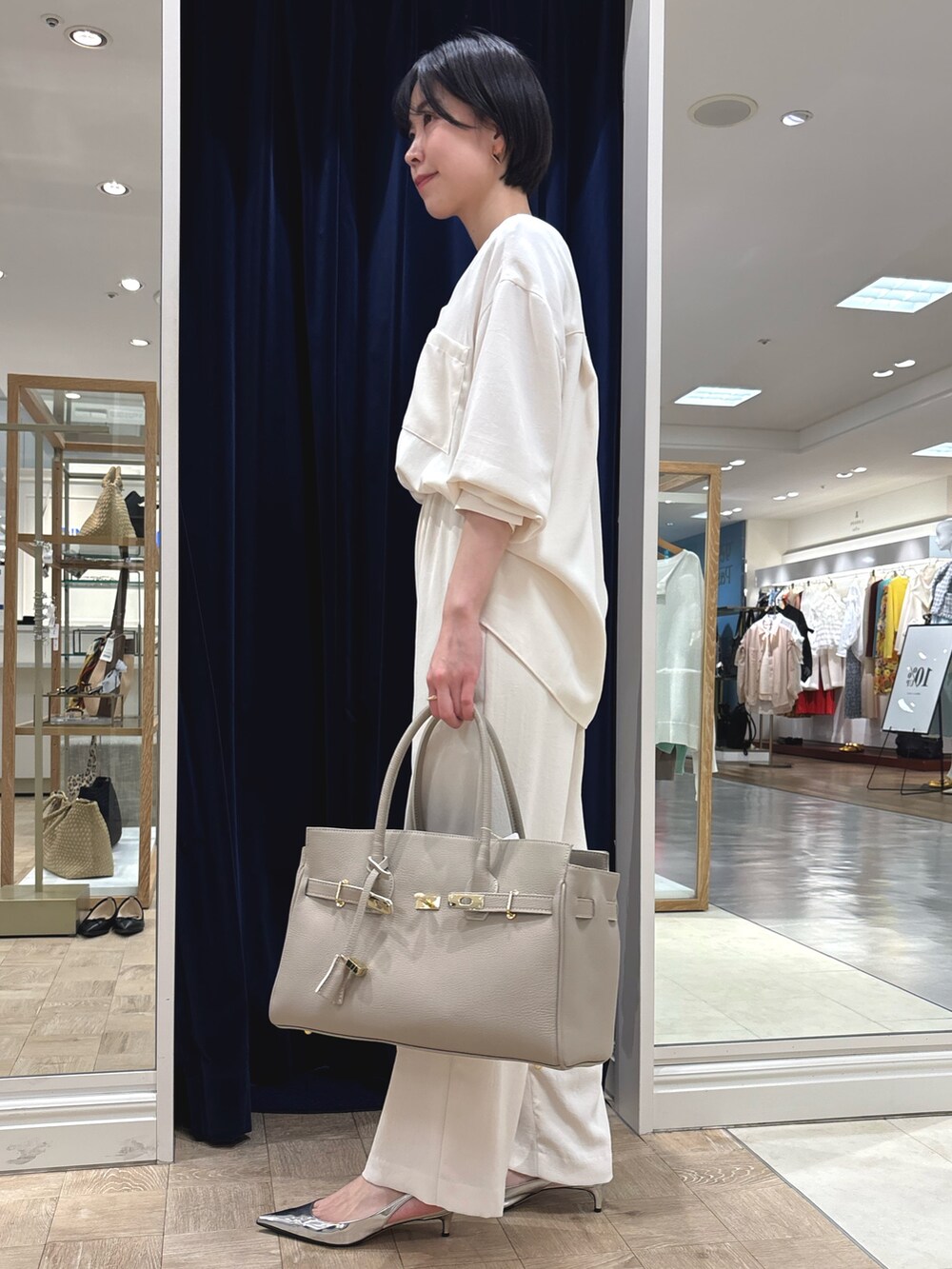ホワイト系のシャツ/ブラウス、ホワイト系のその他パンツ、ベージュ系のトートバッグを着用したレディースの春コーディネートの4枚目の写真