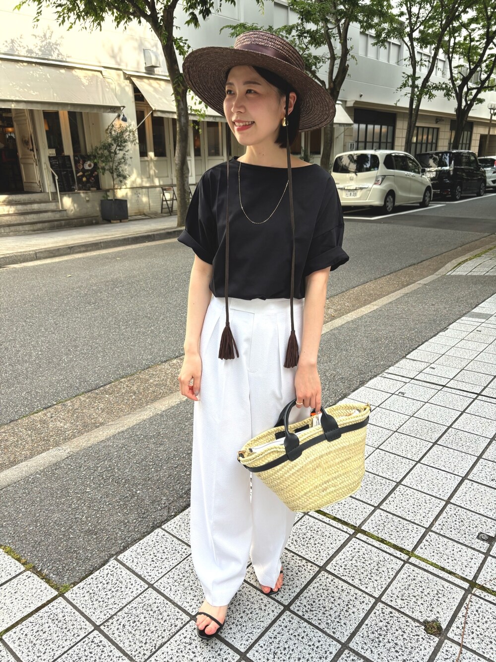ホワイト系のその他パンツ、ブラック系のTシャツ/カットソー、ブラック系のかごバッグを着用したレディースの夏コーディネートの7枚目の写真