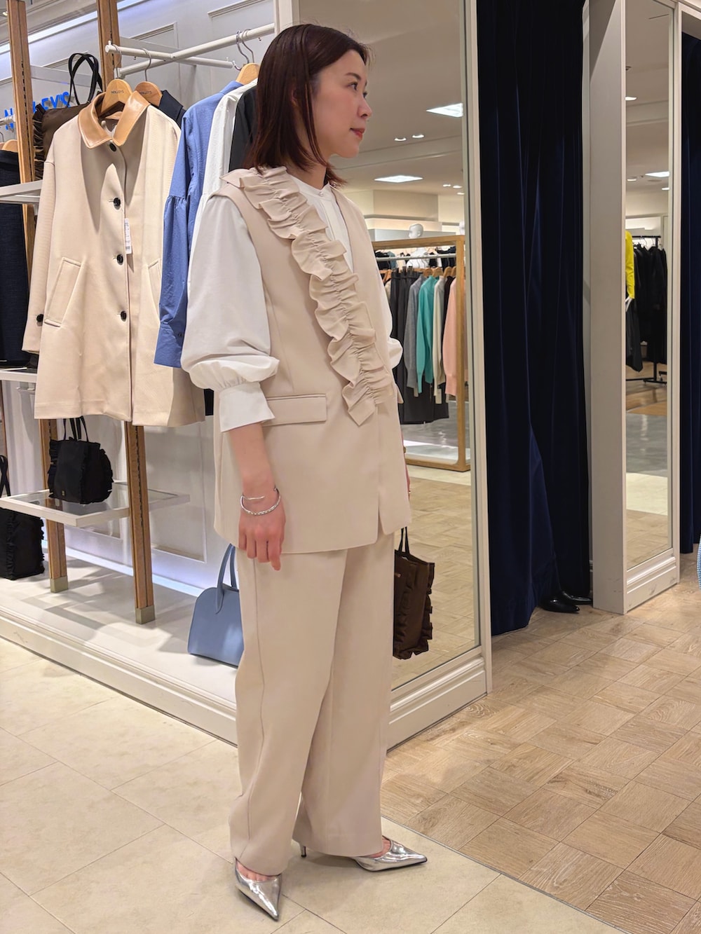 ホワイト系のベスト、ホワイト系のその他パンツ、ブラウン系のショルダーバッグを着用したレディースの冬コーディネートの5枚目の写真