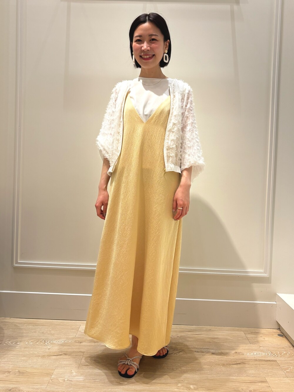 イエロー系のワンピース、ホワイト系のブルゾン、ホワイト系のTシャツ/カットソーを着用したレディースの夏コーディネートの2枚目の写真