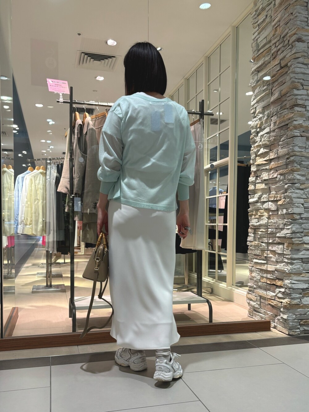 ホワイト系のスカート、ブラック系のショルダーバッグ、ホワイト系のTシャツ/カットソーを着用したレディースの春コーディネートの4枚目の写真