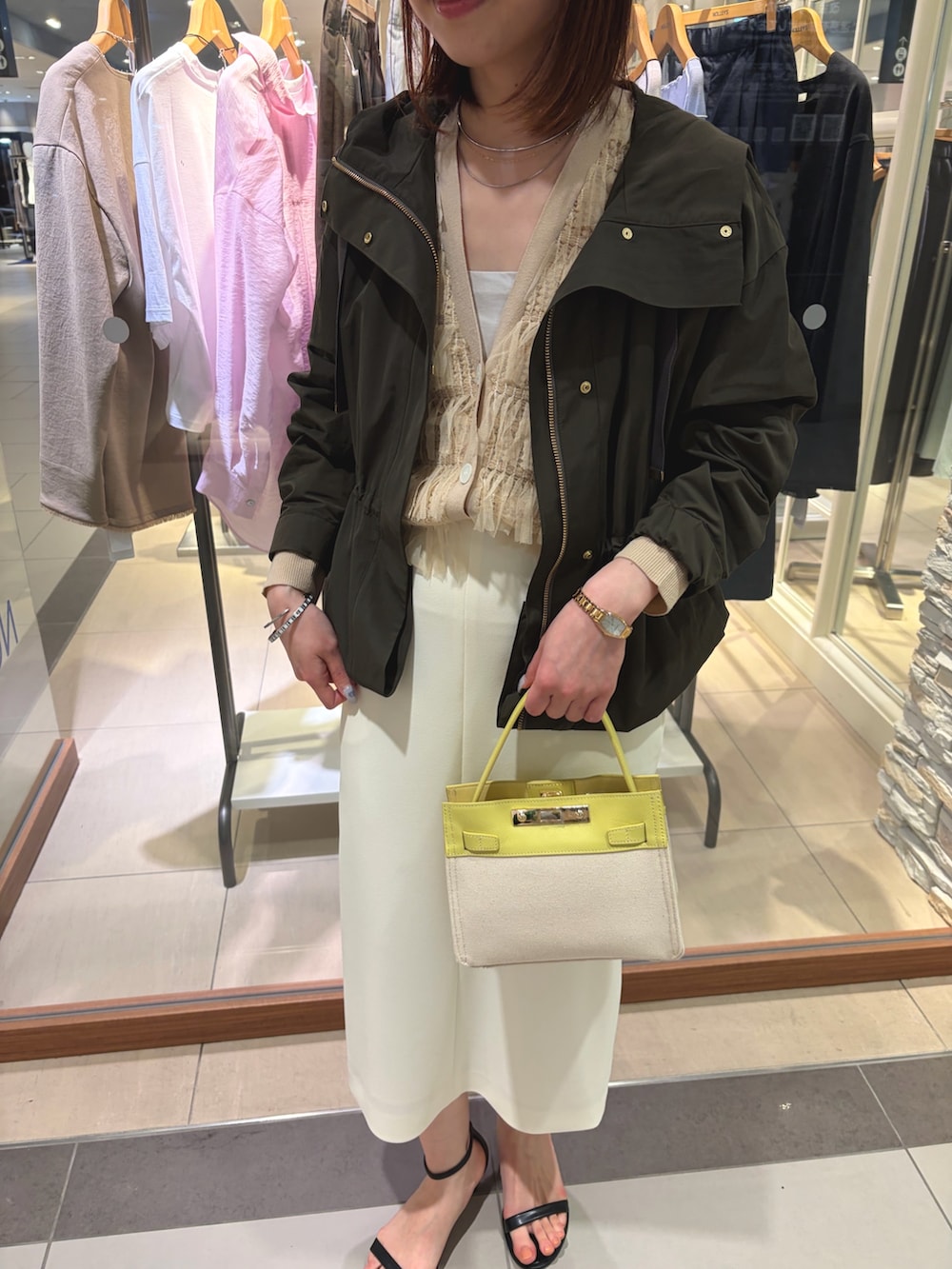 ホワイト系のスカート、イエロー系のショルダーバッグ、ベージュ系のカーディガン/ボレロを着用したレディースの春コーディネートの6枚目の写真