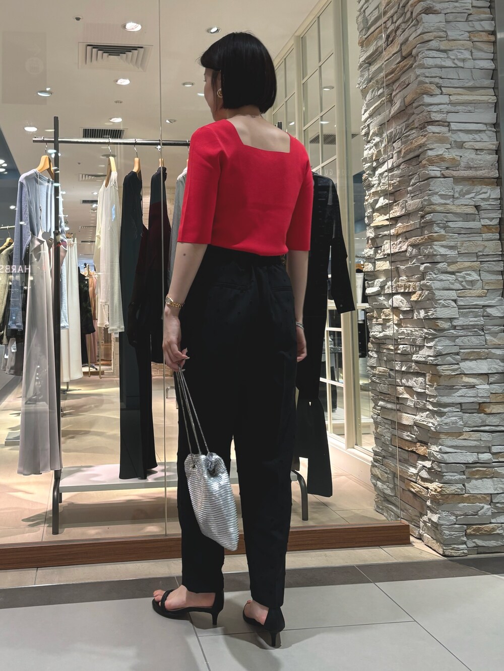 ブラック系のその他パンツ、シルバー系のショルダーバッグ、レッド系のニット/セーターを着用したレディースの夏コーディネートの4枚目の写真
